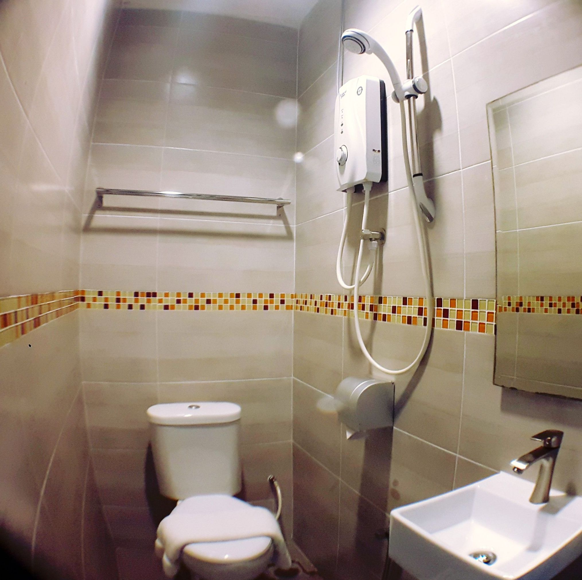 A bathroom with a toilet, a shower, and a sink.