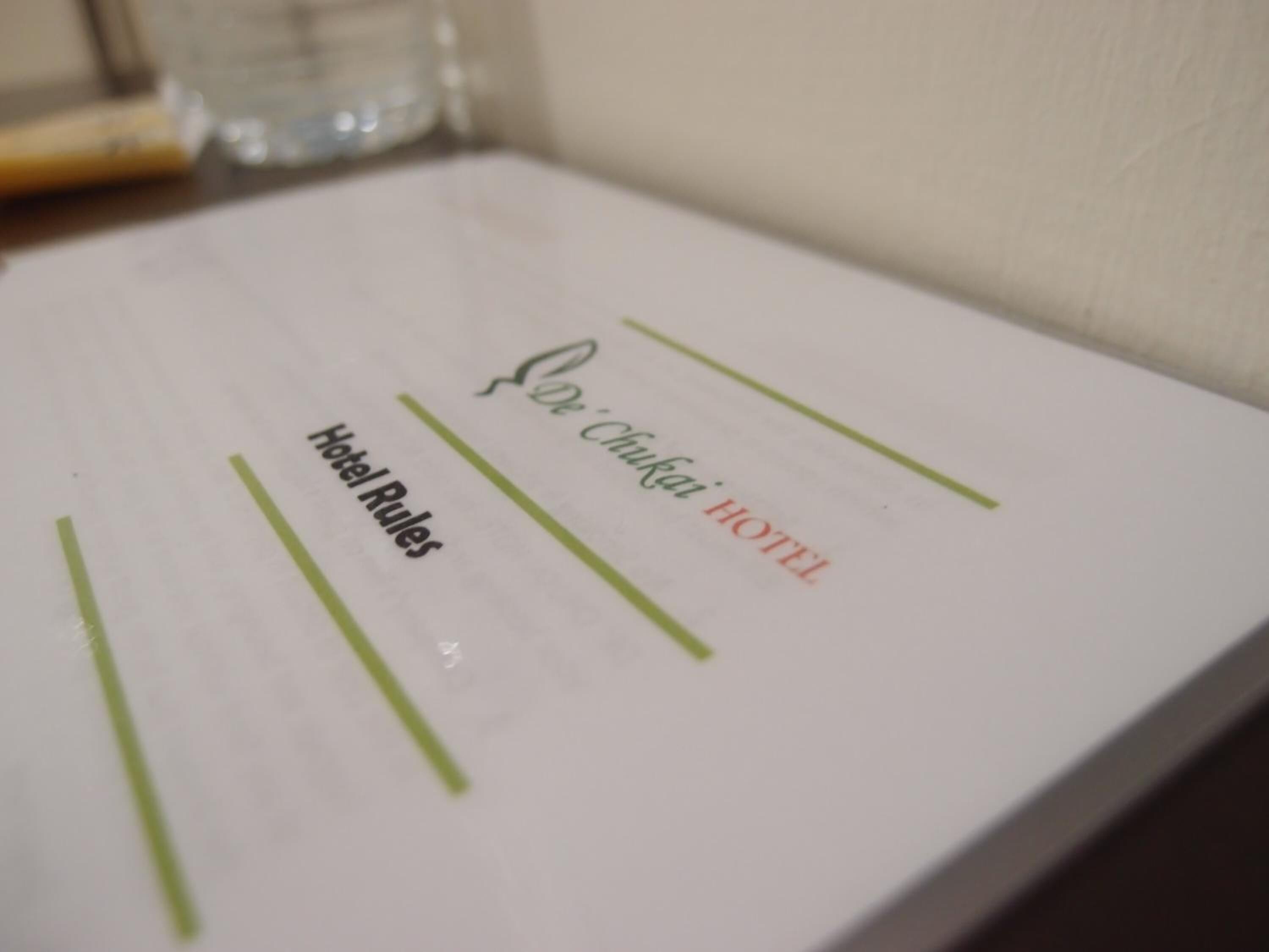 A hotel room sign with 'Hotel Rules' and 'De'Chukai HOTEL' written on it.