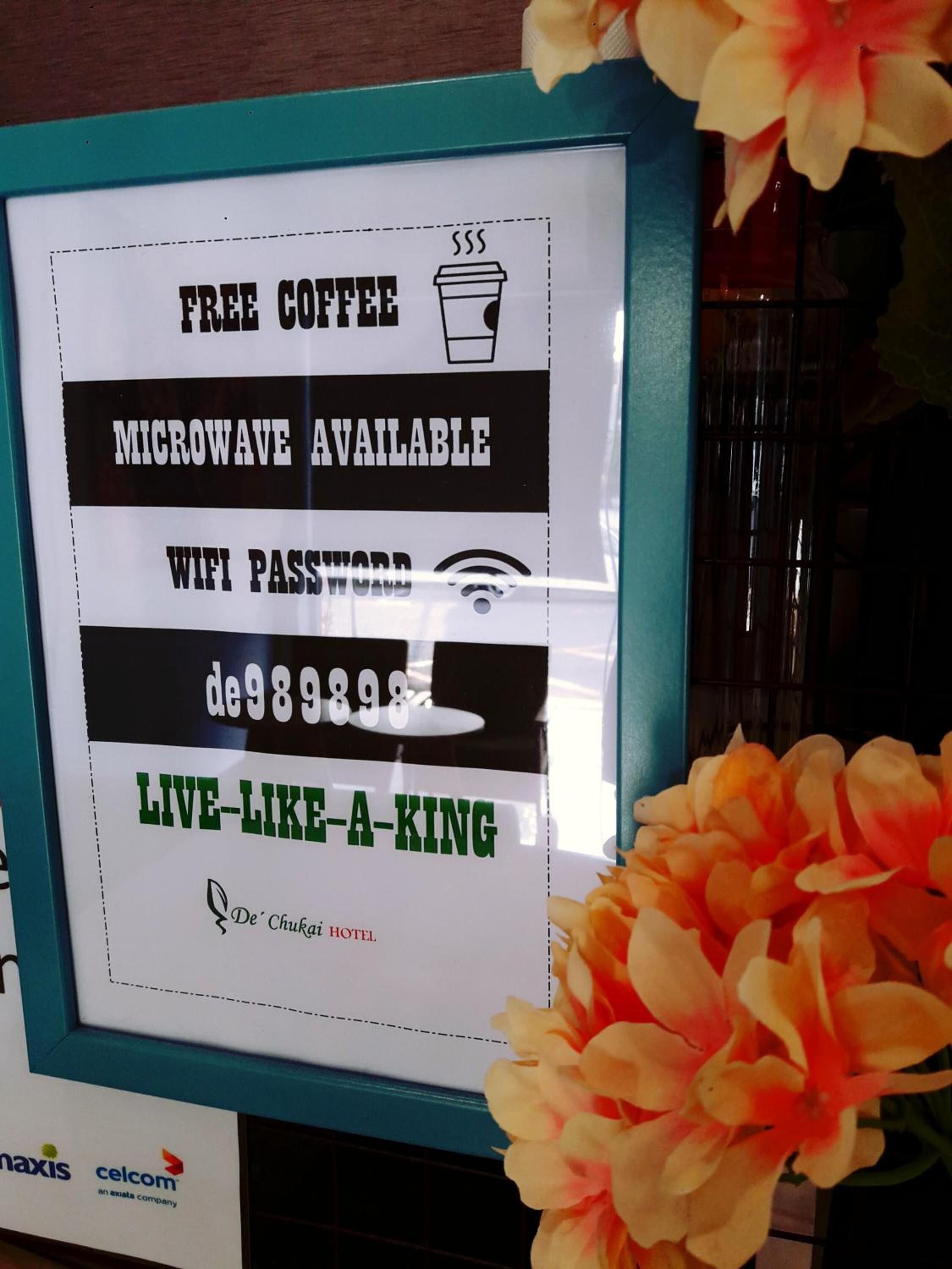 Señal que ofrece café, microondas y acceso a WiFi gratis en el Hotel De' Chukai.
