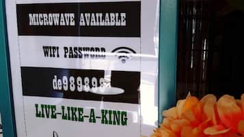 Señal que ofrece café, microondas y acceso a WiFi gratis en el Hotel De' Chukai.