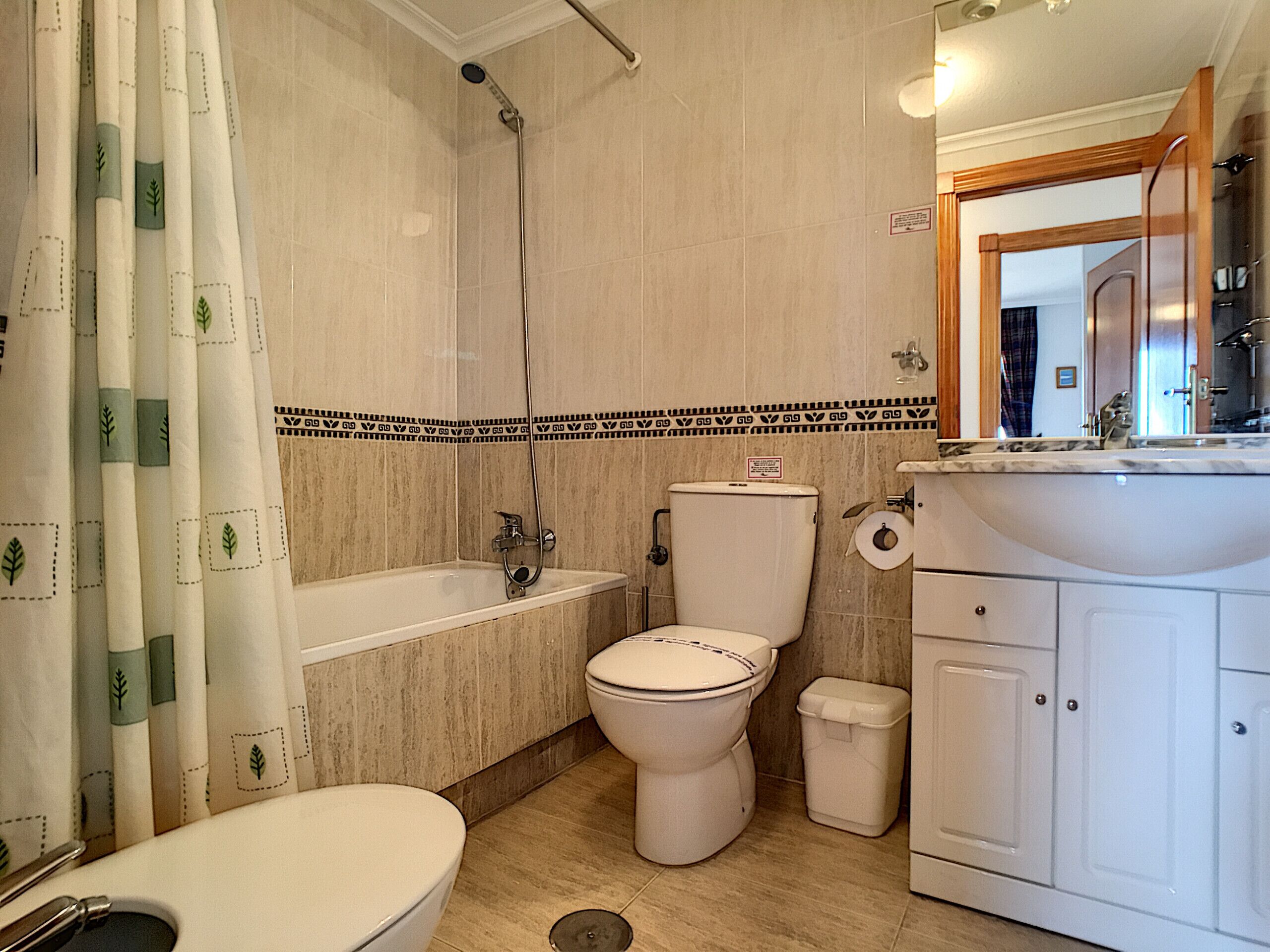 A bathroom with a bathtub, toilet, and sink.