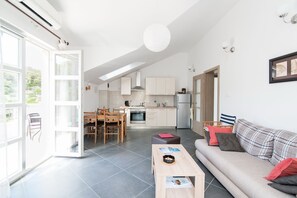 A modern apartment with a dining area, kitchen, and living room.