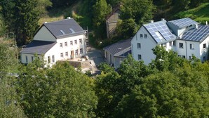 Ein Wohngebiet mit modernen Häusern, die mit Solaranlagen ausgestattet sind, umgeben von üppiger Vegetation.