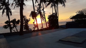 A sunset view with palm trees and a beach. - Bali Apnea Club - Hostel (Kubu)