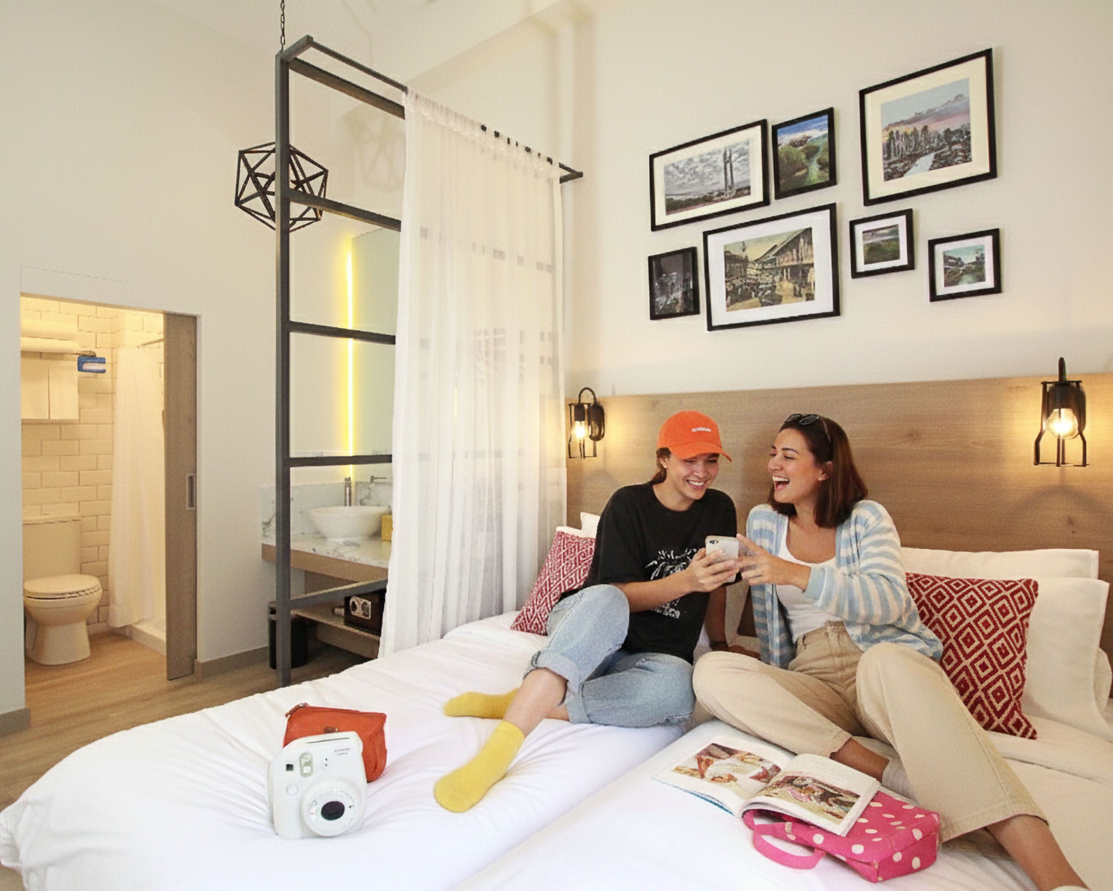 A bedroom with a bed, a bedside table, a camera, and a magazine.