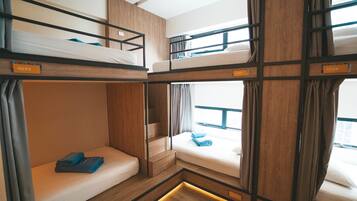 A bunk bed room with wooden frames, a small window with curtains, and a label with the number 4092.