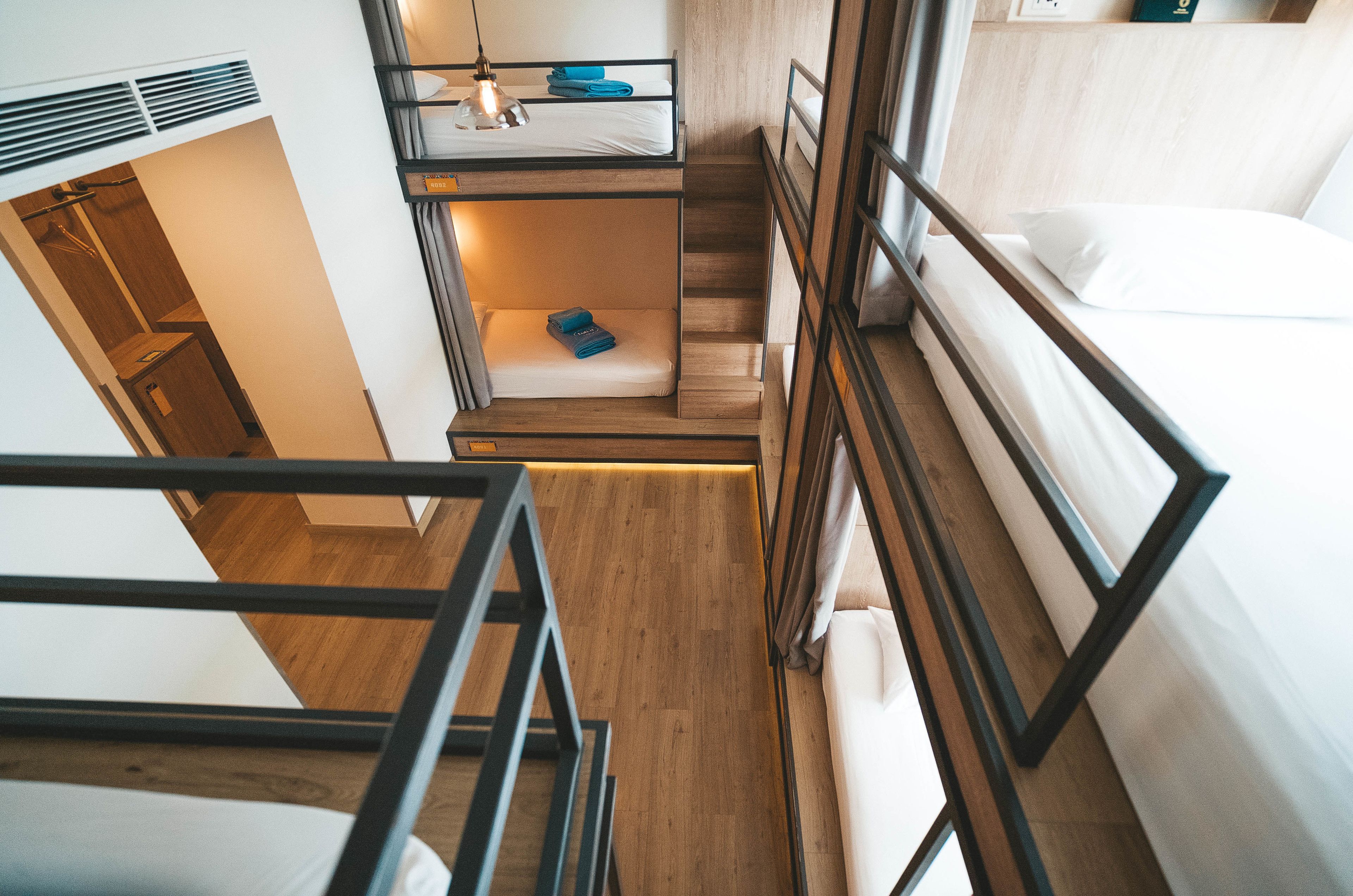 A multi-level room with bunk beds, a small desk, and a wardrobe.