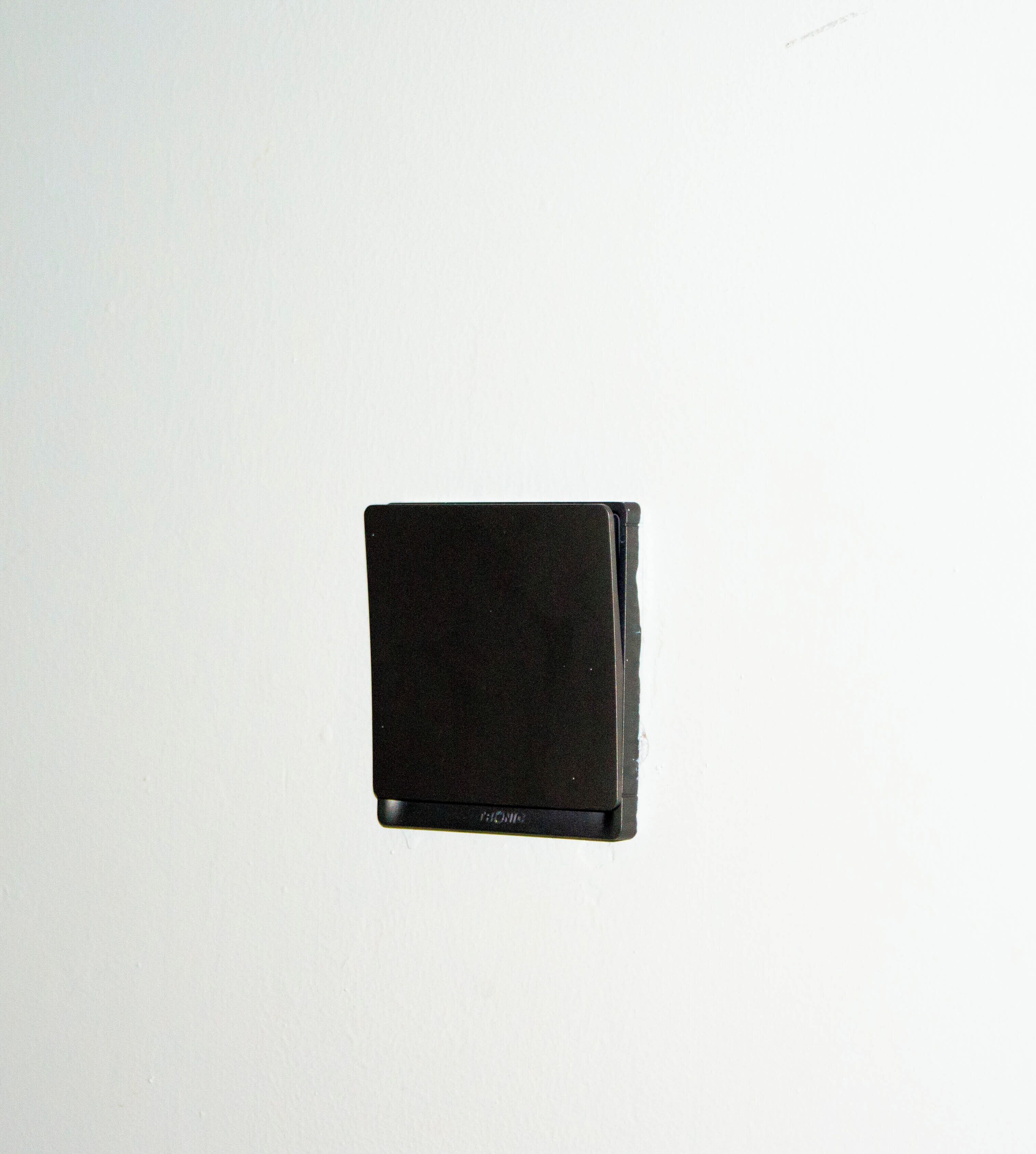 A black object with the word "PIONEER" on it, mounted on a white wall.