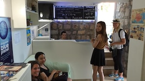 A reception area with a counter, a chalkboard with information, and a map on the wall. - Hostel Angelina Old town Dubrovnik (Dubrovnik)