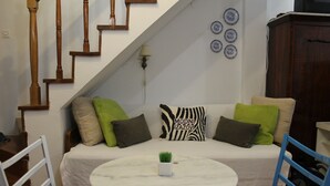A cozy living area with a sofa, a small round table, and a staircase. - Hostel Angelina Old town Dubrovnik (Dubrovnik)