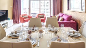 A dining area with a table set for six, featuring a modern design with patterned tableware and glassware. - Luxury Staycation - Continental Tower (Dubai)