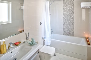 A modern bathroom with a bathtub, a sink, and a toilet.