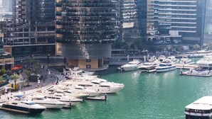 A marina with multiple yachts docked, surrounded by high-rise buildings. - Luxury Staycation - Continental Tower (Dubai)