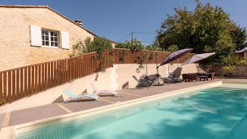 Een buitenzwembad, parasols voor strand/zwembad