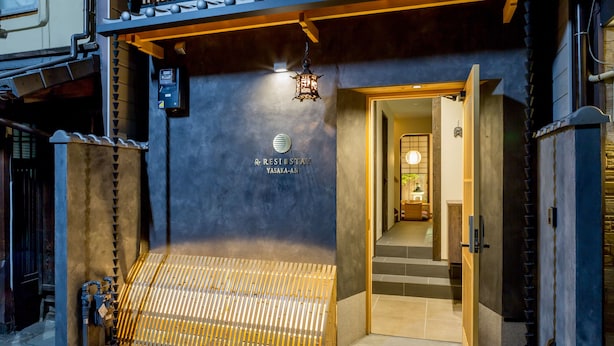 The exterior of a hotel with a modern entrance, a wooden bench outside, and a sign indicating the name 'RESIDENCE YASAKA-AN'. - RESI STAY Yasaka-An (Kyoto)