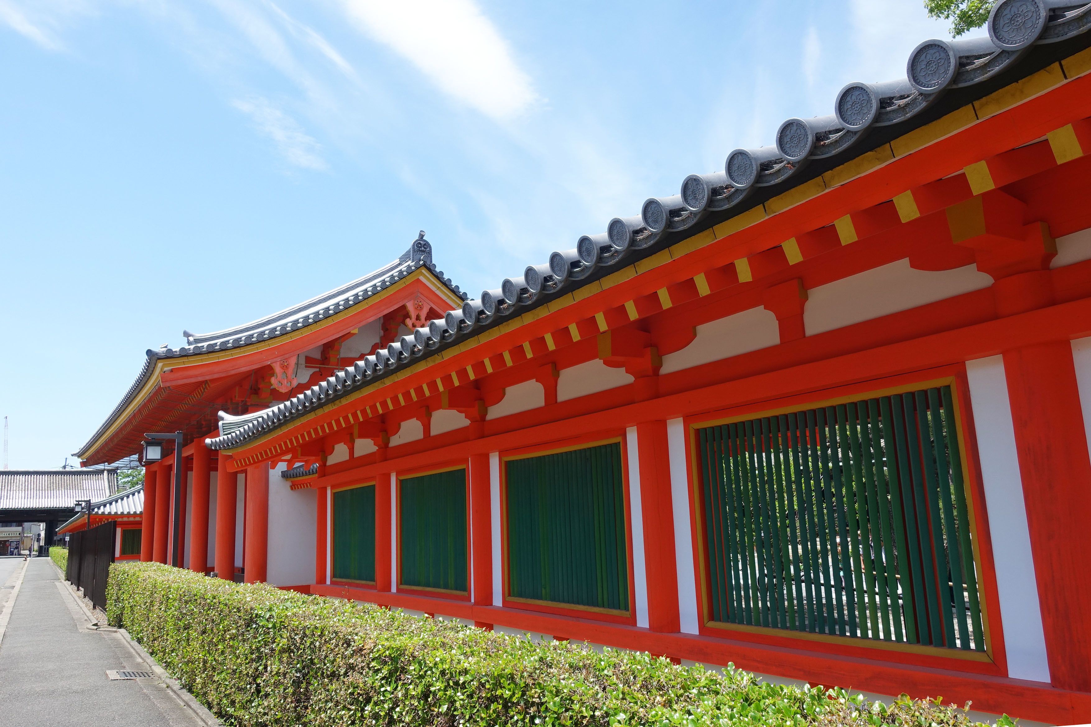 A traditional red and white building with a curved roof and green windows.