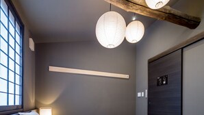 A bedroom with two beds, a window, and a wooden beam ceiling. - RESI STAY Yasaka-An (Kyoto)