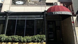 Um hotel com uma grande placa na fachada com a inscrição "Time Hotel" e "Mecidiyeköy Time Hotel".