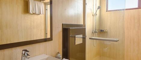 A modern bathroom with a large sink, toilet, and glass-enclosed shower.
