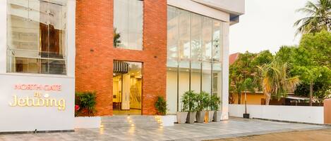 Un edificio moderno con fachada de ladrillo, grandes ventanales y un letrero que dice "NORTH GATE by Jetwing".