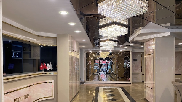 A reception area with a marble floor, a reception desk, and chandeliers. - Alfin Hotel Ankara (Ankara)