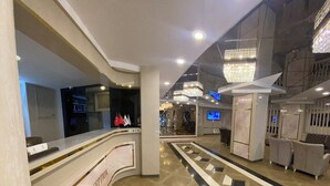 A reception area with a curved counter, a reception desk, and a tiled floor with a geometric pattern. - Alfin Hotel Ankara (Ankara)