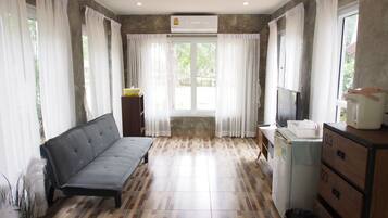 Una habitación con sofá, lavadora y televisor.