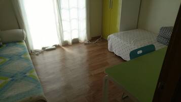 Una habitación con cama, escritorio y armario.