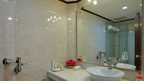 A modern bathroom with a large mirror, a white sink, and a toilet. - Hotel Baljees Regency (Shimla)