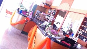 Eine Bar mit einer Theke, Barhocker und einer Auswahl an Flaschen und Gläsern.
