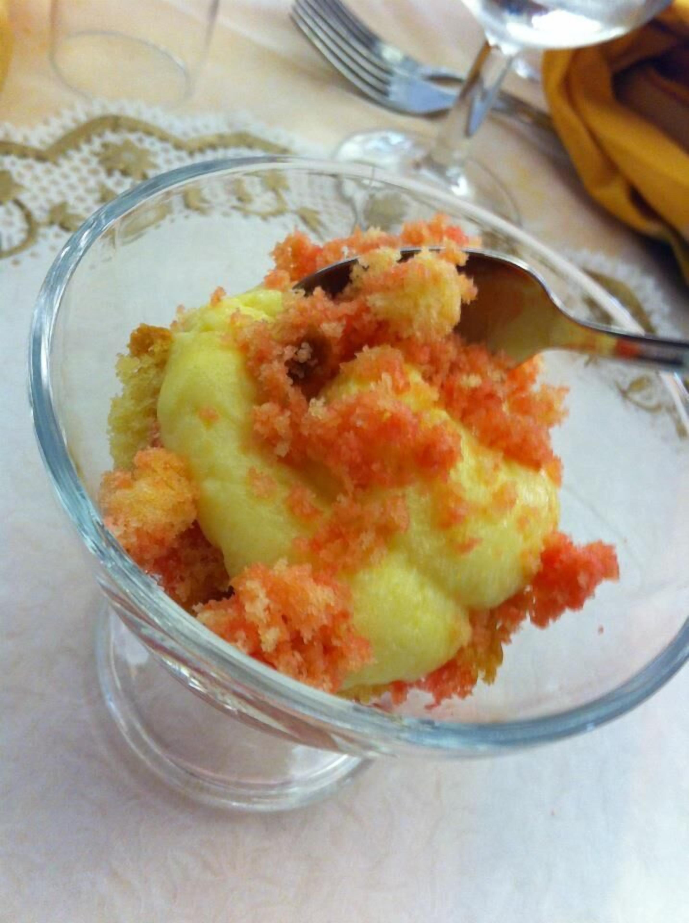 A dessert in a clear glass bowl with a spoon.