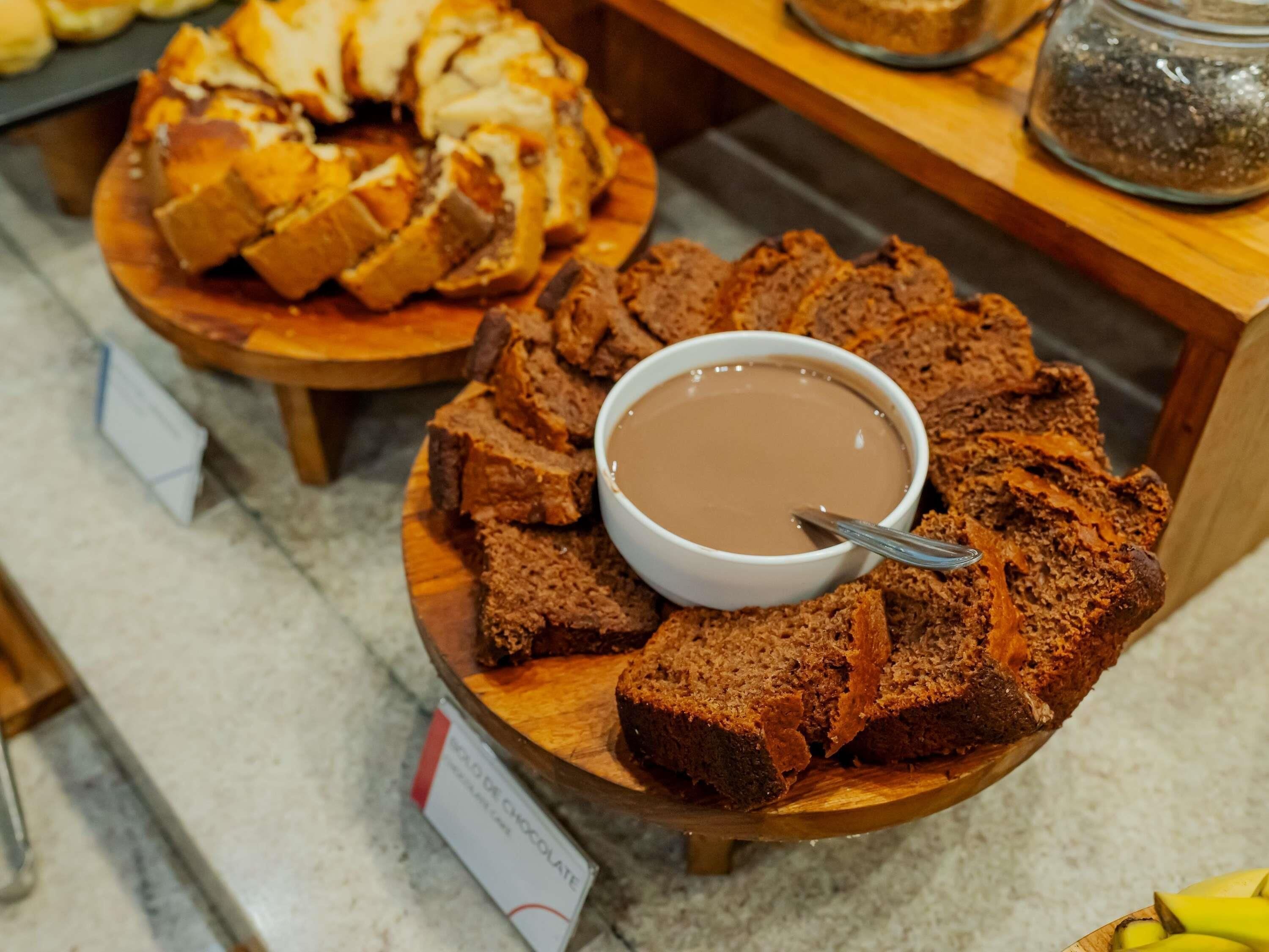 Una presentación de brownies y una salsa de chocolate sobre tablas de madera.