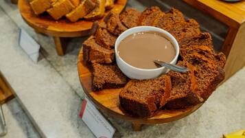 Una presentación de brownies y una salsa de chocolate sobre tablas de madera.