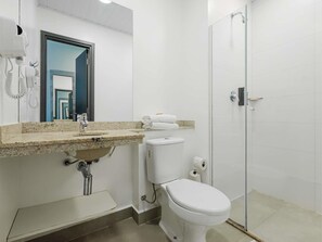 Une salle de bain avec un lavabo, des toilettes et une douche.