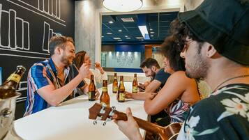Un grupo de personas sentadas alrededor de una mesa, conversando mientras hay botellas de cerveza.