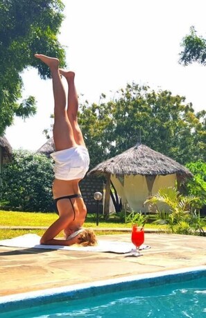 Una piscina al aire libre, sombrillas, sillones reclinables de piscina
