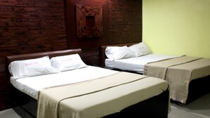 Une chambre d’hôtel avec deux lits, des murs en bois et un mur d’accent de couleur verte.