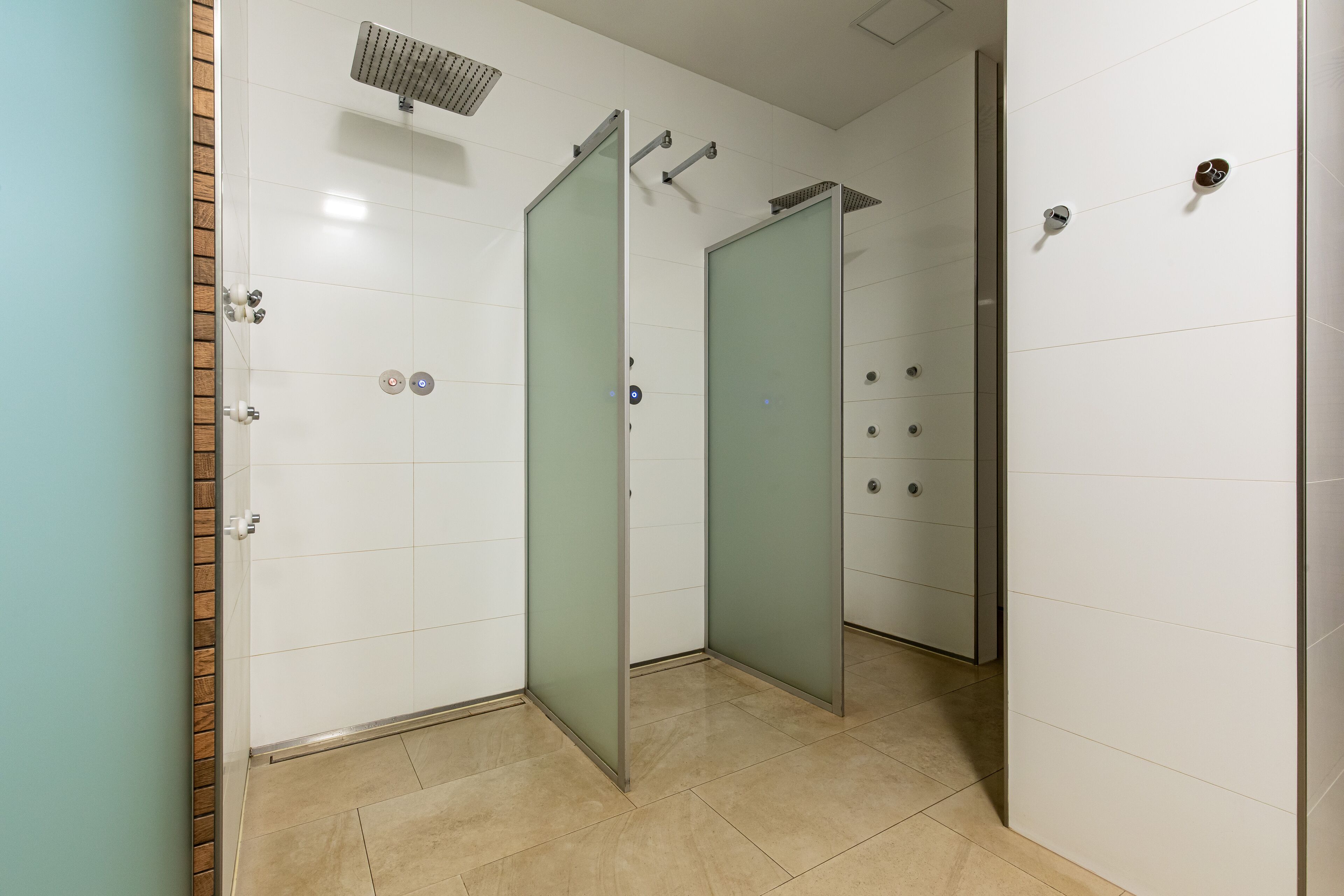 Un baño moderno con ducha, puertas de cristal y suelo de baldosas.