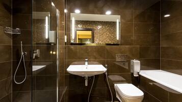 Un baño moderno con ducha envuelta en vidrio, un lavamanos y una bañera.