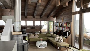 Un salon chaleureux avec une cheminée, un canapé, une table basse et une bibliothèque.
