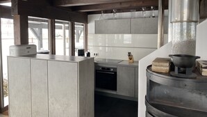 Une cuisine moderne dotée d’une grande cuisinière, d’appareils électroménagers en acier inoxydable et offrant une vue sur l’extérieur.