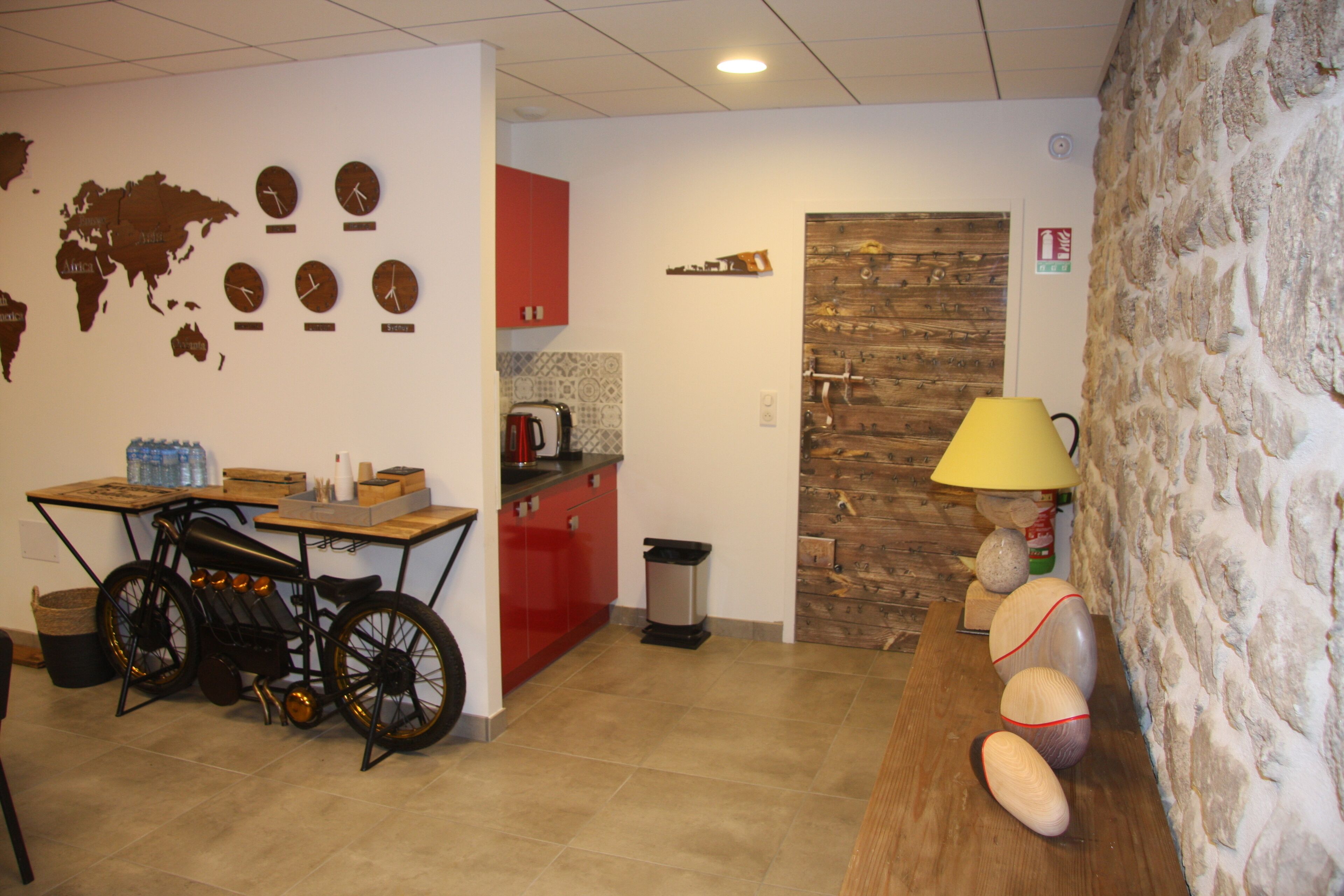 A kitchen with a bicycle, a wooden door, and a stone wall.