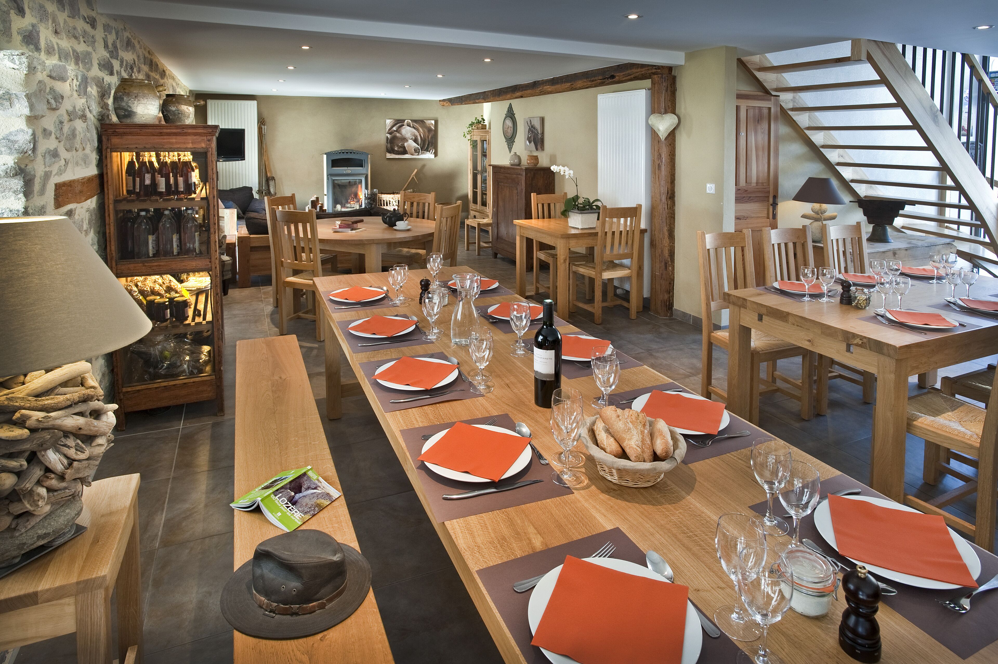 A dining area with multiple wooden tables set for a meal, surrounded by chairs.