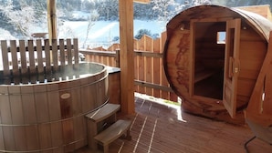 A wooden hot tub and sauna area with a wooden deck and a view of a snowy landscape. - Les Granges de Bigose (Rimeize)