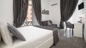 A hotel room with a bed, a desk, and a chair. - Suite Dei Catalani (Naples)