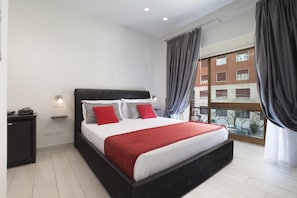 Une chambre d’hôtel moderne avec un grand lit, une table de chevet, une fenêtre avec des rideaux et une vue sur le paysage urbain.