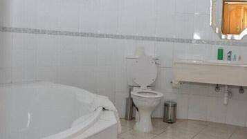 A bathroom with a bathtub, toilet, and sink.