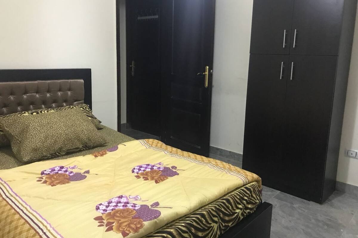 Une chambre à coucher avec un lit, une armoire et une porte.