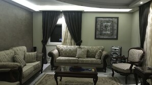 A living room with a sofa, armchairs, a coffee table, and a rug. - Maadi Royal Palace (Cairo)