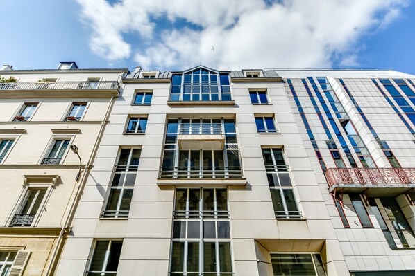 A multi-story building with a mix of architectural styles, featuring large windows and balconies. - Sweett | Milan VI - Four Bedroom Apartment, Sleeps 10 (Paris)